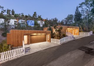 These 11 Modern Fences Bring a Whole New Meaning to Curb Appeal - Photo 3 of 11 - The two separate structures were given a visual unity by cladding them with a specially fire-treated cedar siding on the exterior. The white picket fence is another visual tie between the properties.