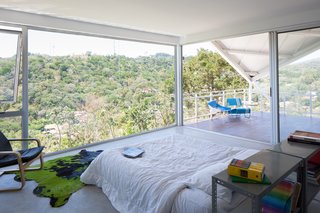 Striking Green House with a View in El Salvador - Photo 7 of 7 - Floor-to-ceiling glass walls give the residents the illusion of living outdoors.