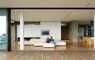 Achilleas and his girlfriend Alexia lounge on an Extrasoft sofa by Piero Lissoni for Living Divani.