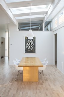 Sunny Renovation of an Eichler Great Room - Photo 5 of 5 - The area that was formerly the atrium now houses the dining room. The table is Room & Board, and the pendants IKEA. The poster is another Herman Miller trade poster found at a Berkeley shop.