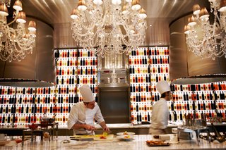 A pair of chefs prepare dishes in the open kitchen at Raffles' one Michelin-starred restaurant, La Cuisine, described as "refined, generous, and spontaneous French cuisine."