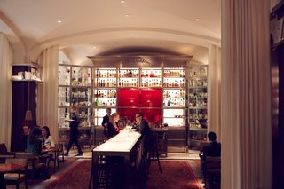 Located at the heart of the hotel, Le Bar Long, is a high, long, narrow and luminous bar. Designed by Philippe Starck, the structure is broken up by large white linen curtains, artwork, a fantastic array of lamps and chandeliers and the repetitive face-to-face layout between patrons and a bartender moving behind a bar breaks up the conventional look of a bar.