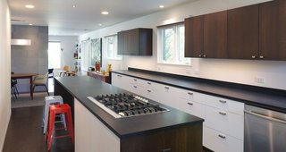 Renovating a Modern House in a Historic District - Photo 4 of 6 - Paperstone countertops and custom cabinets outfit the kitchen. The cooktop is by Whirlpool.