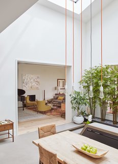 In Chicago’s Buena Park, dSPACE Studio transformed a disorganized 1978 home into a bright retreat that revolves around an expanded atrium. SoCo pendant lights by Tech Lighting draw the eye up to the double-height light well.