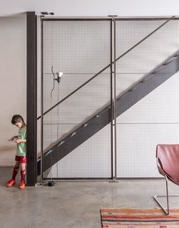 A Rooftop Garden Completes This Urban Pastoral Home - Photo 7 of 11 - The sculpture on the wall is by artist Peter Dudek, a friend of the family, and the pendants are by Glashütte Limburg. Baumann made a point to integrate industrial materials throughout, exposing steel beams and setting the floor in concrete.