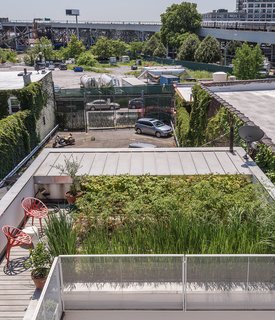 Building on the site of a former one-car garage, an architect created this family’s home in an evolving, industrial neighborhood of Brooklyn. "We have all these different destinations," says Lisa Sardinas, the resident and a writer who works from her home office. "I’ll be working, get stuck on a passage, and take a break to go read outside." On the lower roof, red Vegetal chairs by Erwan and Ronan Bouroullec for Vitra provide moments for repose.