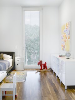 15 Modern and Creative Spaces For Kids - Photo 3 of 15 - The upper two levels of the home are set back from the street, increasing privacy and allowing light to flow uninhibited from the front clerestory window into the communal living spaces. On the top floor, the children's bedrooms are strategically veiled from the street by the slatted reflector screen.