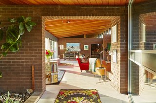 Quirky 1970s House in the English Countryside Showcases an Amazing Modern Furniture Collection - Photo 1 of 18 - Sheridan Coakley, owner of the London-based furnishings purveyor SCP, uses his circa-1970s home as a testing ground for the furnishings he carries in his company’s inventory. In the foreground, a Balzac lounge chair by Matthew Hilton is draped with a Donna Wilson blanket.