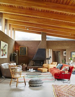 Quirky 1970s House in the English Countryside Showcases an Amazing Modern Furniture Collection - Photo 16 of 18 - In the open-plan living and dining room, a dramatically sloped roofline allows for generous clerestory windows.