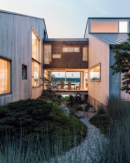 Gray Organschi took down a worn-out 1970s summer home and reinvented it as a serene pair of bleached cedar volumes connected by a glass bridge.