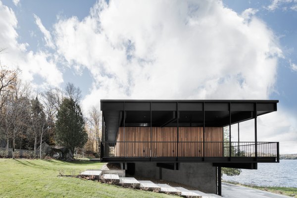 The original design did not exploit the lower part of the house, so Carle added a bar and lounge area facing the lake at the ground level. He also installed water-based geothermal heating in the basement. “It allows the concrete floor to be heated and to generate most of the heating of the house, while a second smaller air pump assures a supplement of air on the ground floor and air conditioning for summer.” Photo 6 of The Phoenix modern home