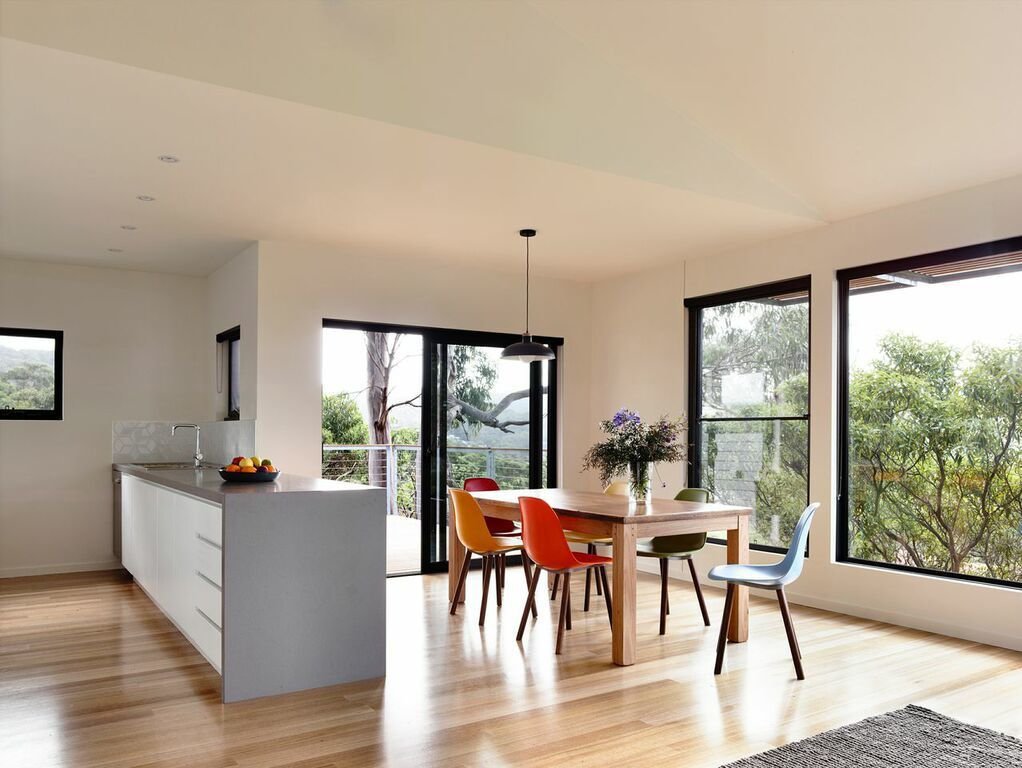 The central living area features an open-plan kitchen, living space, and deck with views of Louttit Bay. To maximize energy savings, the house has a ducted reverse air cycle system from Fujitsu.