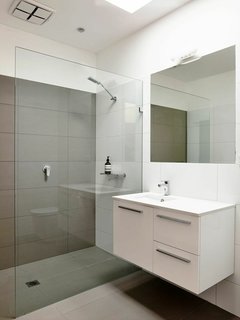 A Breezy Modern Beach House Sits Among the Trees in Australia - Photo 5 of 8 - "Keeping the kitchen and bathrooms simple saved money for the important things," Harkness explains. They went with a soothing color palette and hardware from Reece.