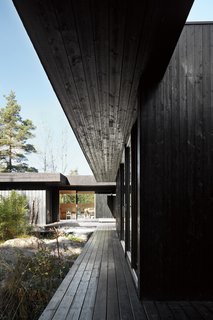 30 All-Black Exterior Modern Homes - Photo 14 of 30 - Sævik compares her house to a contemplative hideout. "It’s very quiet," she says. "You can concentrate and let thoughts fly." Her favorite summer pastimes include reading, painting, drawing, yoga, and "just sitting and feeling the forest," she says.