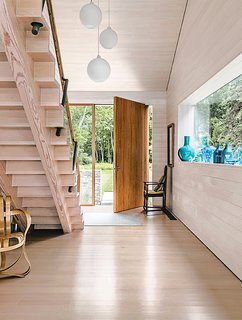 The highlight of the east wing entry is the oversize front door, fabricated by JIG Design Build, which swings open on a pivot hinge.