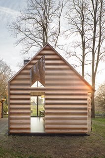 The house may appear conventional at a glance, but a closer look shows how Oostenbruggen has pushed the boundaries of the traditional gabled typology. It has an asymmetrical roof, with slate shingles that extend down the eastern side to close it off completely.