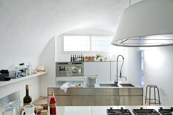 Modern Meets Ancient in a Renovated Italian Vacation Home - Photo 7 of 8 - In the minmalist kitchen: sleek steel cabinet systems and the Kono range hood from Elmar.