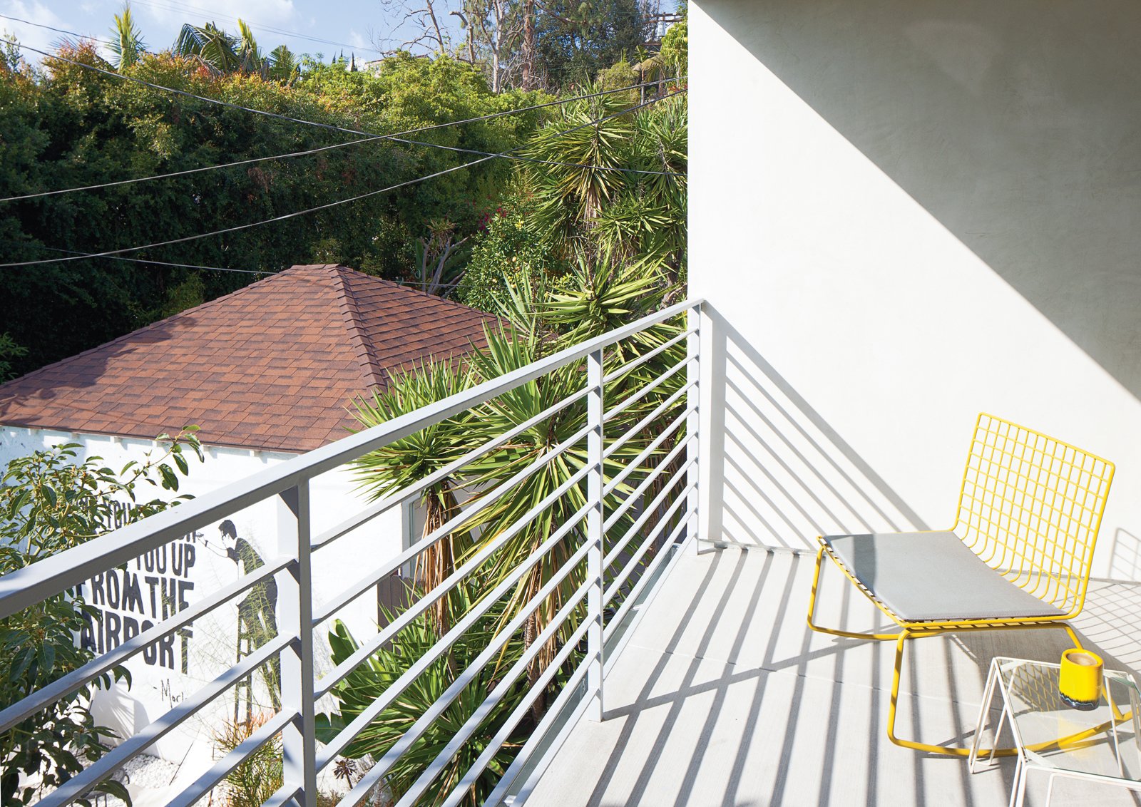 On the balcony off the master bedroom is a yellow Hatfield Grellow rocker from CB2.
