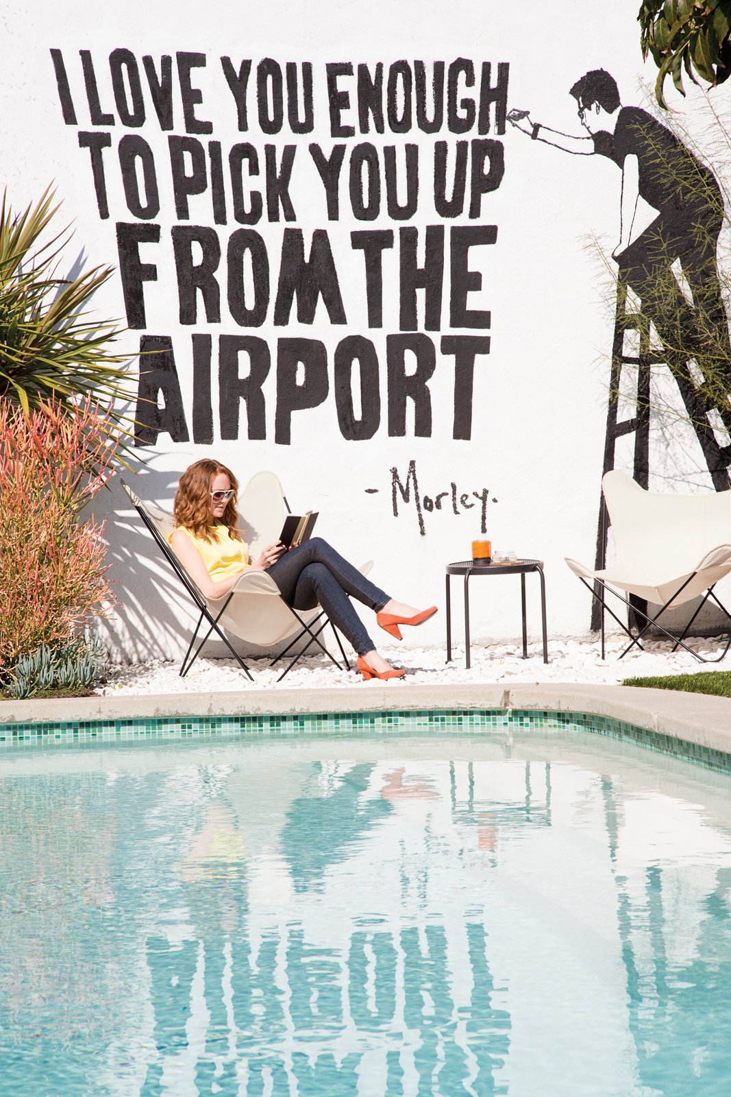 Classic butterfly chairs from Universal Patio Furniture are stationed by the pool. The mural is by street artist Morley, a close friend.