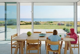 At a family-friendly summer getaway in Sweden, this home is oriented to take advantage of sea views. The dining table is from ILVA, and the CH36 chairs by Hans Wegner are from Carl Hansen & Søn. 