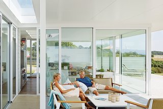Henrik and Karin Lepasoon relax in their outdoor seating area that faces the ocean. They purchased the property in 2005 and began building five years later. "We used to take road trips in Europe every summer," says Henrik, "but when Oskar was born we thought it would be nice to be in one place."