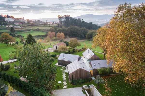Four distinct structures make up the house. Their design echoes the shape of an older, gabled-roof building already on site. “We considered the neighboring construction quite interesting in terms of scale and layout,” de Carvalho says. “Due to the proximity, we felt the necessity to integrate it in the design.” Photo of House of Four Houses modern home