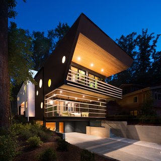 An Angular Futuristic House in Georgia - Photo 7 of 7 - A screened-in porch was a must-have for the residents (they love to sit outside but hate mosquitoes) and influenced the building's asymmetrical shape. "The question became how can we integrate this into the design of a modern house," says architect Staffan Svenson. "Can it be a screen porch without looking like one?" He devised a plan to hang a horizontal louver system from the structure to give the illusion that the powder-coated steel fins hover in place. He used the same material for the guard rail on the second story.