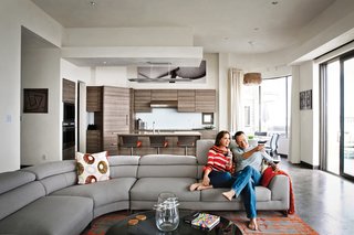 Bryan Cranston and his wife, Robin Dearden, relax on a Lagune sofa by Roche Bobois. The couple’s home occupies a beachfront site that they’ve owned for several years. The original structure, affectionately dubbed the "love shack" was born as 1940s-era military housing that in subsequent decades became an uneven hodgepodge that defied local permits and was slowly sinking into the sand.<br><br>To learn more about the Cranston Residence project and its players, please visit www.3palmsproject.com