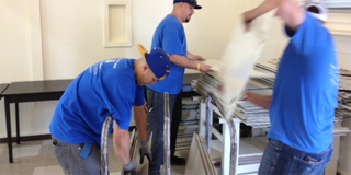 An installation crew from ANEW nationwide network assembling donated workstations at Samuel Gompers Middle School in Watts. The surplus came from partner DIRECTV.
