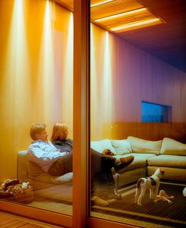 The sliding doors to the deck are made by Dynamic Architectural Windows & Doors and the sofa, on which Chapoton and Buser sit is from Dellarobbia.