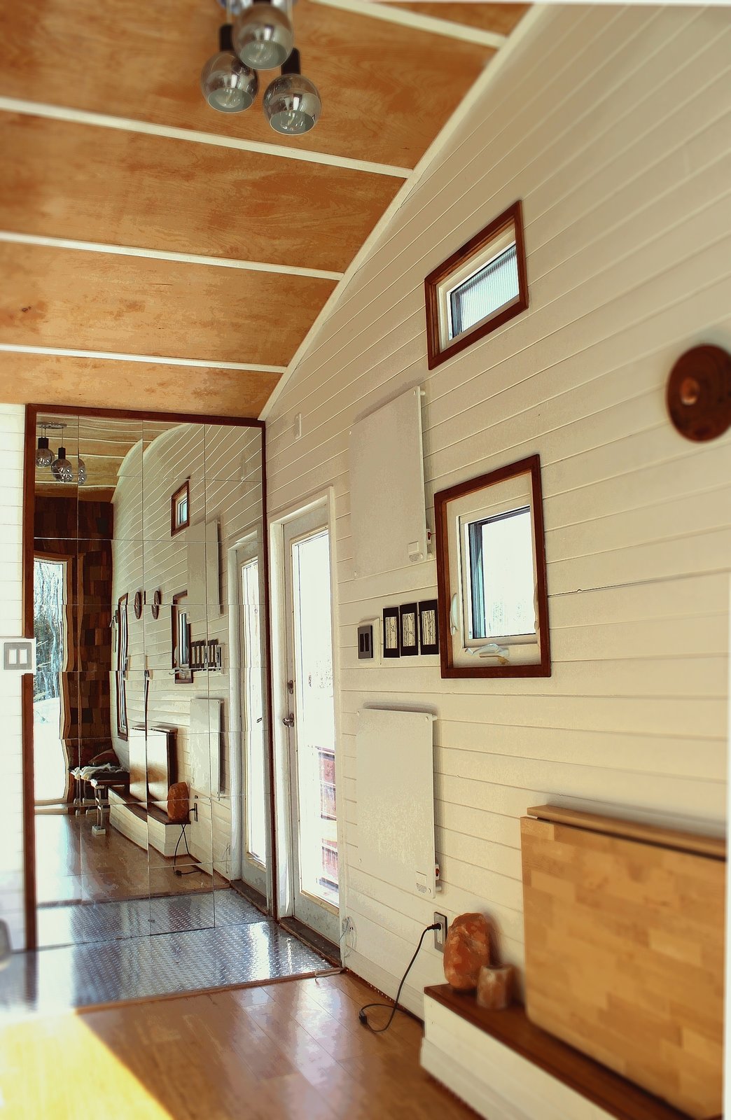 Herbert used laminate bamboo flooring inside the Leaf House. An inexpensive light fixture, which Herbert found in a thrift shop, hangs from the birch-plywood ceiling.