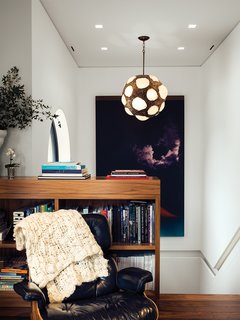 Eames Lounge Chair Porn - Photo 34 of 53 - At the top of the stairwell, a sitting area is outfitted with a vintage Eames lounge, a large Jack Goldstein painting, and a 1970s light fixture found by Marcovitz in Paris.