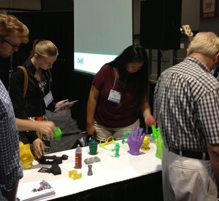 Dwell on Design visitors inspect objects printed on the Cube, a 3D printer.