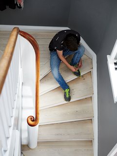A Cramped Attic Became a Sunny Dining Room in this Renovation of a Copenhagen Tudor - Photo 3 of 12 - Charrier’s son, Fabian Fonnesbæk Charrier, 14, pauses on a staircase of white oil-finished pine floorboards.