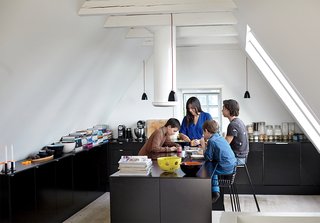 A Cramped Attic Became a Sunny Dining Room in this Renovation of a Copenhagen Tudor - Photo 9 of 12 - With three sons in the family, the kitchen gets a lot of use. Hee barstools by Hee Welling for Hay slide up to a multi-functioning island where the family gathers to eat, study and play.