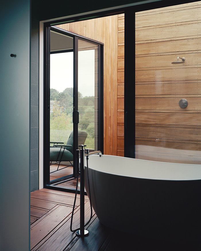 40 Modern Bathtubs That Soak In the View The master suite’s bathroom unfolds from a glass-walled bathing room, outfitted with a Signature Hardware tub and Lefroy Brooks fixtures, to an open-air shower.
