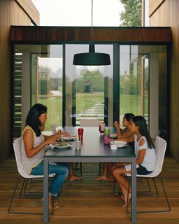 For the outdoor dining room, interior designer Damon Liss selected a Soho pendant lamp by Joan Gaspar, Trennza chairs from Janus et Cie, and the Portica outdoor table from Room & Board. The sliding glass doors are by Arcadia.