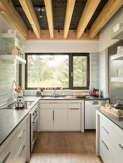 An Artist Builds a Wooden Home That Lets Nature Be the Boss - Photo 3 of 7 - Cambrian black granite countertops were installed in the kitchen. "One of the favorite things I have to do in the kitchen is wash dishes, just because it’s such a delightful view out the window," Bullitt says.