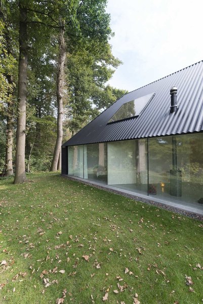 The house's "traditional" feel, Koolhaas says, is "only as thick as the layer of wood on the outside." When entering, the eyes travel straight back through the massive windows to the green yard beyond. "It appears as though there is no house behind the facade, like the houses on a movie set," he says. Photo 3 of Triangular House modern home