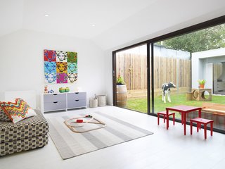 The cozy "rumpus room," a kids playroom that functions as a second living room, looks out onto the courtyard. The space was designed to encourage kids’ creativity, while complementing adult tastes. With the addition of a movable wall, the space can be sectioned off so children can be seen but not heard. Functional and durable white cork flooring completes the child-friendly space.