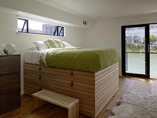 In the second floor master bedroom, a custom captain’s bed designed by the homeowner, features drawers and storage underneath. Its towering height allows for views out the nearby window.