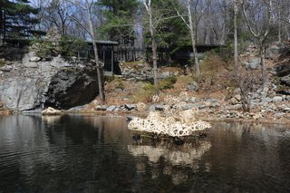 The house and studio were christened "Dragon Rock" by their daughter Ann who said the rock formation resembled a dragon sipping from the pool. The pool was created by feeding a waterfall into to the pit. Seen here is a floating sculpture by current artist-in-resident Stephen Talasnik.