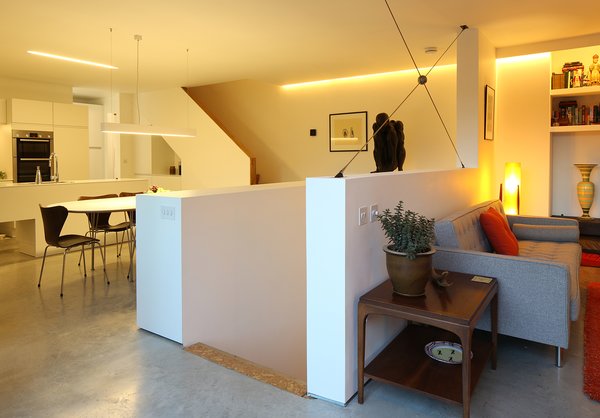 The Piet Hein Superellipse dining table adjacent to the kitchen is homeowner Andrew Pennock's favorite part of the house. He enjoys watching the changing light while drinking coffee, eating meals, and using the space as a home office. Having the main living area elevated on the second floor is "a delight," says Pennock. It "takes you away from street level and offers a slightly different perspective on the world." Photo 7 of Ferrum House modern home