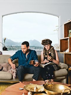 45 Pets in Beautiful Modern Homes - Photo 5 of 45 - In the living room of their Vancouver home, Omer Arbel and Aileen Bryant sit on a Coronado sofa by Afra and Tobia Scarpa for B&B Italia. They are joined by their Weimaraner, Bowie, boa constrictor, Picasso, and milk snake, Legs.<br><br>"I have a casual approach to prototyping that involves our day-to-day life. I am always tinkering, and I have lots of transformers to run electricity through things, but Aileen lives with me now, so I have to be respectful. Before she moved in it was like a total madhouse; now I can’t pour concrete in the kitchen. It is a collaboration in a sentimental sense. This work is my life, and the objects are my objects, but how they are arranged and the flow of each room are something we’ve created together here."