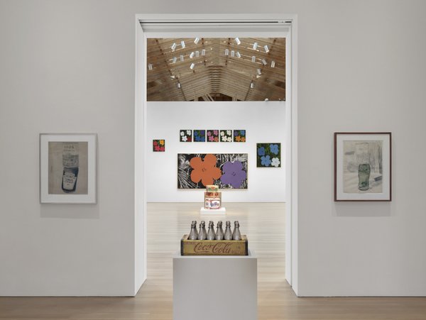 From Warhol’s famous hyper-color prints of hibiscus flowers (background), to his little known (unreleased) perfume collaboration (contained within the silver Coke bottles in front).<br><br>Credit Stefan Altenburger, Courtesy The Brant Foundation