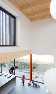 This Blackened Timber House Triumphantly Emerges After a Fire - Photo 5 of 6 - To highlight the views and avoid clutter in a multipurpose space, the van Bolderen brothers, in cooperation with Originele Staat interior design firm, used stainless steel countertops and added screenprinted Dibond aluminum plates to the standard kitchen cabinetry. The window frames are by MHB.