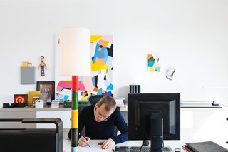 Interior architect and resident Renaud de Poorter works in his second-floor office at a pair of Joyn tables by the Bouroullec brothers and an Ypsilon office chair by Mario Bellini for Vitra.