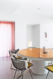 The couple has a fondness for mid-century designer Harry Bertoia, whose steel side chairs for Knoll ring the concrete dining table that they designed.