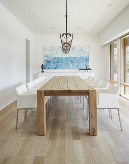 The floors are gray-stained white oak, and the dining room table is from Restoration Hardware.