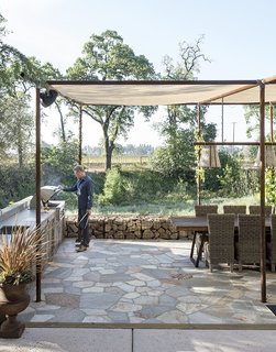There are many examples of prefab homes designed in partnership with other smaller components, such as this covered outdoor room serving as a summer kitchen and dining room. Separating the heat created by cooking from the main home creates less need for cooling.